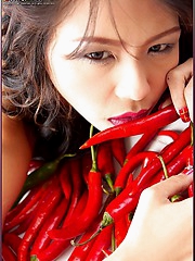 Naomi Chatee lays on a bed of hot peppers